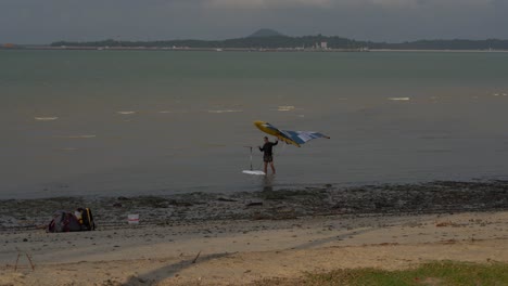 Man-surf-wing-foiling-at-Changi-Beach-late-afternoon,-Singapore