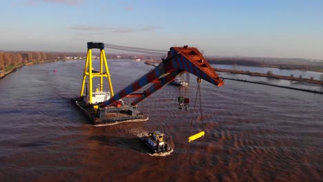 Aerial-View-Of-Boom-From-Hebo-Lift-9-Floating-Crane-As-Its-Being-Pulled-By-Tug-Boat-On-Oude-Maas
