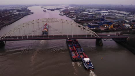 Aerial-View-Of-Maas-FPS-RIJN-Cargo-Ships-Passing-Underneath-Brug-Over-De-Noord