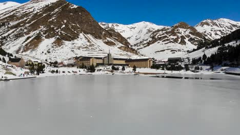Aerial:-flying-above-a-frozen-lake-in-the-pyrenean-valley-of-Nuria