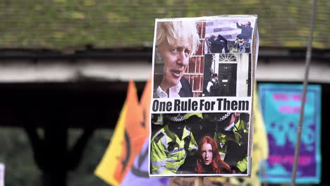 A-placard-depicting-the-face-of-Prime-Minister-Boris-Johnson-and-a-woman-being-arrested-by-police-at-the-Sarah-Everard-vigil-reads,-“One-rule-for-them”