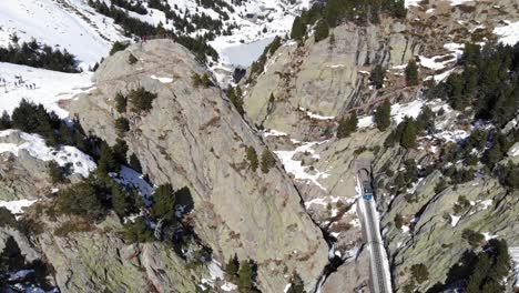 Aerial:-little-rack-railway-entering-a-tunnel-in-the-Pyrenees-in-winter-time
