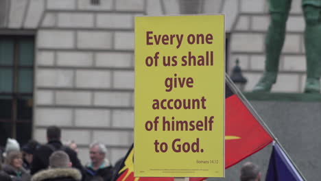 A-yellow-protest-placard-says-“Every-one-of-us-shall-give-account-of-himself-to-God”-on-an-anti-Covid-vaccine-protest