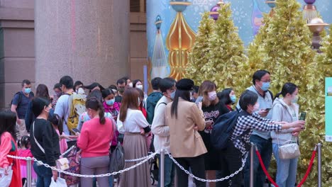 People-queue-in-line-to-access-a-Christmas-theme-installation-event-outside-a-shopping-mall-in-Hong-Kong
