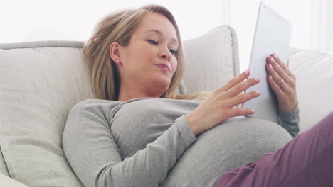Relax,-pregnant-or-woman-on-sofa-on-tablet