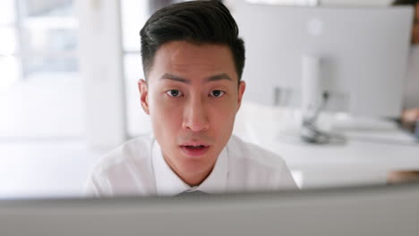 Asian-man,-thinking-and-working-on-computer
