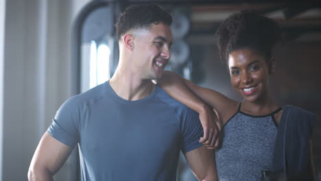 two-fit-young-people-standing-together-in-the-gym