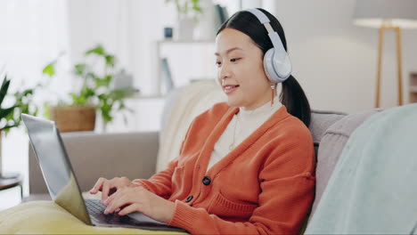 Laptop,-headphones-and-asian-woman-on-couch