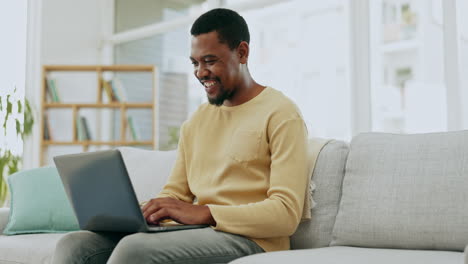 Typing,-laptop-and-black-man-on-sofa-working
