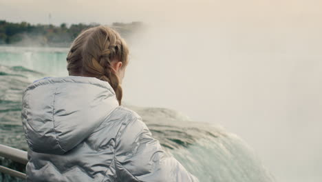 A-girl-in-a-warm-jacket-admires-the-majestic-Niagara-Falls
