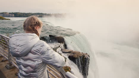 A-child-of-ten-years-old-admires-the-famous-Niagara-Falls.-Travel-in-the-USA