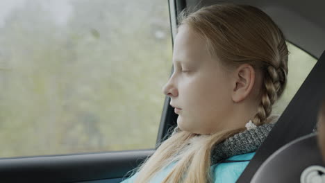 A-girl-of-ten-years-old-rides-in-the-back-seat-of-a-car