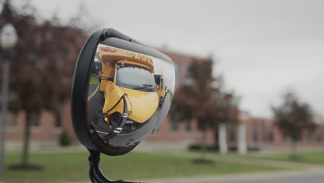 Mirror-of-a-school-bus,-it-reflects-other-buses