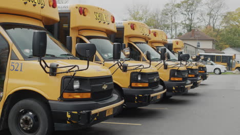 Wilson,-NY,-USA,-October-2021:-Several-yellow-school-buses-stand-in-a-row-in-the-parking-lot-near-the-school.