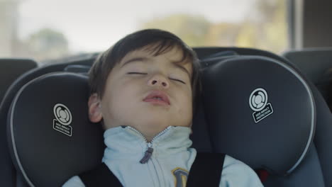 Sleeping-kid-drive-in-the-back-seat-of-the-car.-Asian-baby-sleeps-in-a-child-car-seat