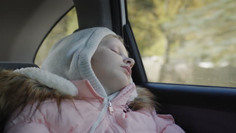 The-child-sleeps-while-driving-in-the-back-seat-of-a-car.