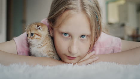 Portrait-of-a-child-with-a-kitten-looking-at-the-camera