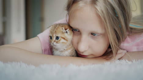 Portrait-of-a-child-with-her-pet---a-ginger-kitten