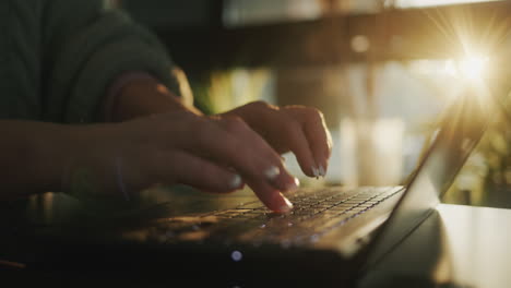 Female-hands-on-the-laptop-keyboard-typing-text.-The-sun-from-the-window-beautifully-illuminates-the-fingers-and-keyboard