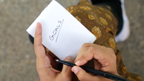 Women-hand-writing-goals-on-a-notepad