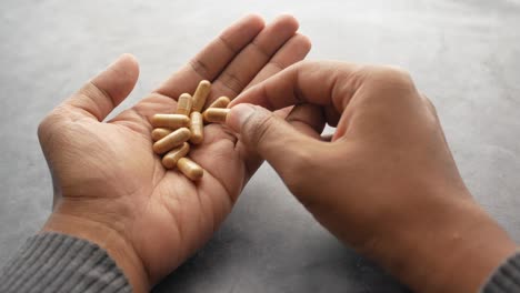 Men-hand-pick-herbal-medicine-capsule-,