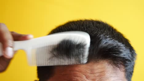 Man-styling-hair-with-comb-close-up