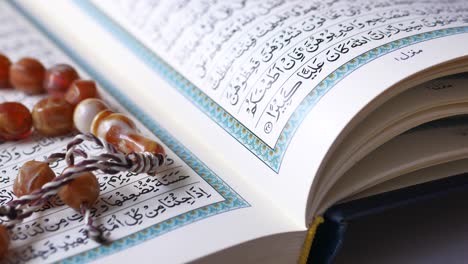 Holy-book-quran-and-rosary-on-table,-close-up