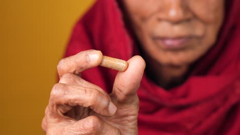 Senior-women-holding-a-herbal-medicine-capsule