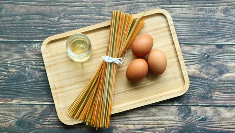 Yellow-long-spaghetti-egg-and-oil-on-table-,