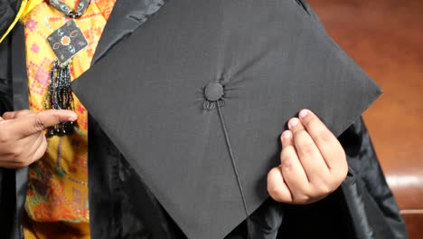 Student-hold-hats-in-hand-during-commencement-success