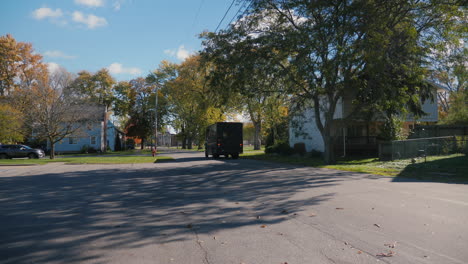 Lockport,-NY,-USA,-October-2021:-An-UPS-postal-truck-drives-through-a-typical-American-suburb