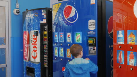 Lockport,-NY,-USA,-October-2021:-The-boy-buys-a-carbonated-drink-from-the-vending-machine.