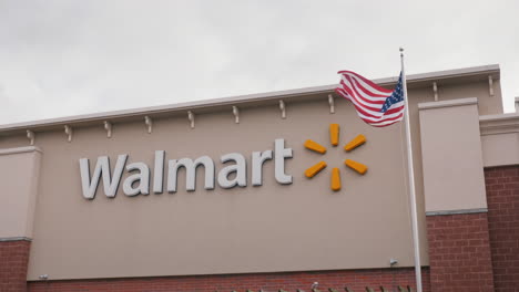Lockport,-NY,-USA,-October-2021:-Walmart-supermarket-sign,-next-to-the-American-flag.-One-of-the-largest-retail-chain-stores-in-the-USA