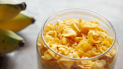 Corn-flakes-,-banana-and-milk-on-table