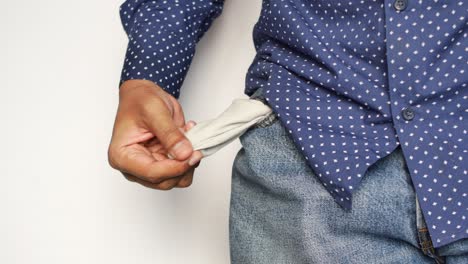 Young-man-shows-empty-pant-pocket-with-copy-space