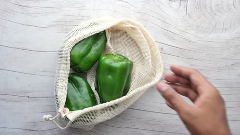 Hand-pick-a-green--capsicum-from-a-shopping-bag-,