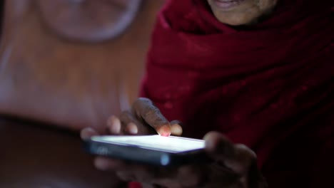 Senior-women-hand-using-smart-phone-at-night-,