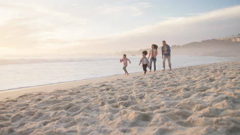 Family,-children-and-running-on-a-beach-together