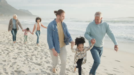 Family,-grandparents-and-dad-swing-girl-on-beach