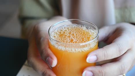 Women-holding-a-glass-of-orange-juice