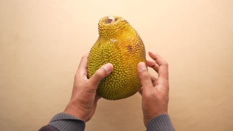 Men-holding-a-jackfruit-top-view-,
