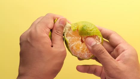 Taking-skin-off-from-a-orange-fruit