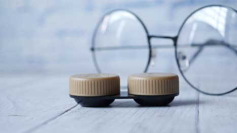 Close-up-of-contact-lens-and-eyeglass-on-table-,