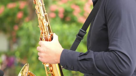 Males-hands-playing-the-saxophone-outdoors