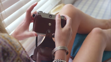 Girl-using-vintage-camera-at-home