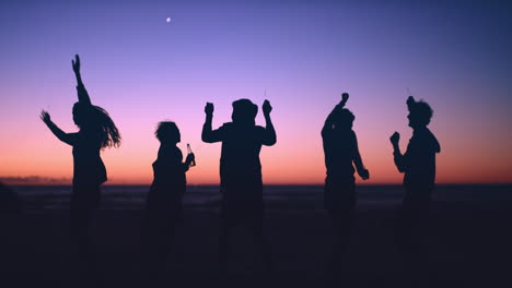 Group-of-friends-dancing-on-the-beach-at-dusk