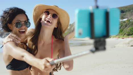 Zwei-Freunde-Machen-Selfies-Am-Strand-Mit-Einem-Selfie-Stick