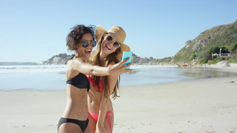 Two-friends-taking-selfies-on-the-beach