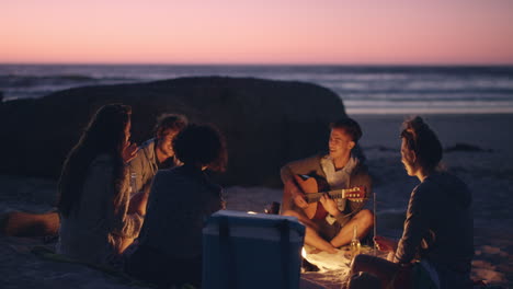 Beach-Party-at-sunset-with-bonfire-and-roasting-marshmellows-with-friends