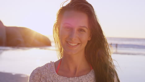 Portrait-of-beautiful-girl-smiling-on-beach-at-sunset-in-slow-motion